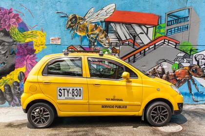 Taxi junto a uno de los murales del barrio.
