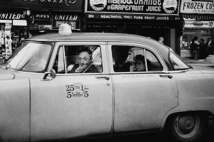 “Taxicab driver at the wheel with two passengers”, NYC, 1956.