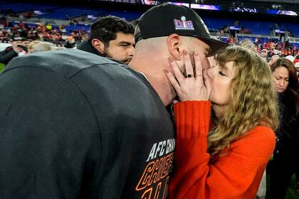 Taylor Swift besa a Travis Kelce, tight end de los Chiefs de Kansas City, tras la victoria sobre los Ravens de Baltimore, el domingo 28 de enero de 2024 (AP Foto/Julio Cortez)