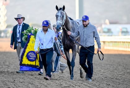 Ted Noffey, llevado por dos asistentes del equipo de trabajo del entrenador Todd Pletcher, tras ganar la Breeders' Cup Juvenile en Del Mar