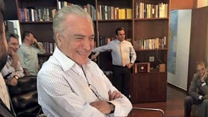 Temer, sonriendo, mirando la televisión, en su despacho del Palacio de Jaburú, con un clima de victoria