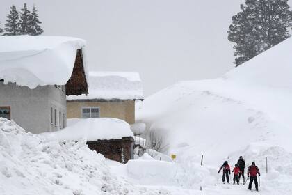 Esquiadores intentan abrir camino en una densa capa de nieve en Filzmoos, Austria