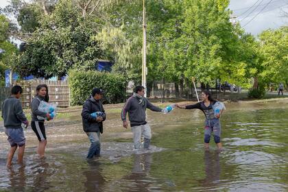 Voluntarios reparten agua entre los vecinos afectados.