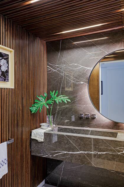 Teñidas en un tono más oscuro que el de la entrada, las varillas de kiri combinan con el mármol ‘Antracita’ (Ragolia). Canillas bimando modelo ‘Zaha’ (Thol)