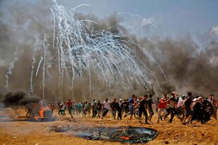 Los palestinos huyen de los gases lacrimógenos lanzados por Israel