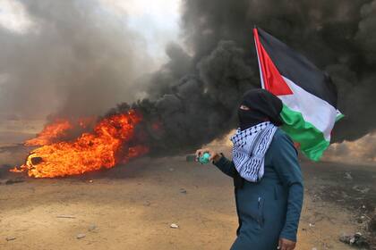 Un palestino lleva la bandera de su país durante las protestas por el traslado de la embajada