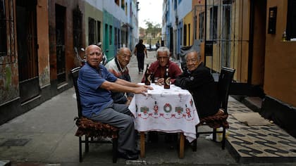 Teodoro Aquino, izquierda, bebe cerveza con sus amigos antes del inicio del campeonato de fútbol callejero el Porvenir en Lima, Perú