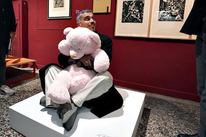 "Teoría de la esperanza" (2016), del austríaco Erwin Wurm: un hombre se abraza a un gran oso de peluche en la exposición donde el juego manda y está permitido tocar