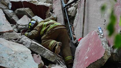 Un rescatista buscando entre los escombros