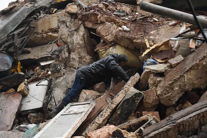 A man looks for survivors under the rubble of a collapsed building after an earthquake in the regime-controlled northern Syrian city of Aleppo on February 6, 2023. - A 7.8-magnitude earthquake hit Turkey and Syria early on February 6, killing hundreds of people as they slept, levelling buildings and sending tremors that were felt as far away as the island of Cyprus, Egypt and Iraq. (Photo by AFP)