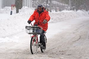 Terrence Yarbrough, de Erie, Pensilvania, viaja en su bici por las calles cubiertas de nieve, en el centro de Erie, el 2 de diciembre de 2024. (AP Foto/Gene J. Puskar)