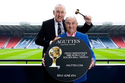 Terry Butcher y Osvaldo Ardiles promocionan la subasta del Balón de Oro que Diego Maradona recibió en 1986, como mejor futbolista del Mundial de México (Prensa Aguttes Auction House / SNS Group)