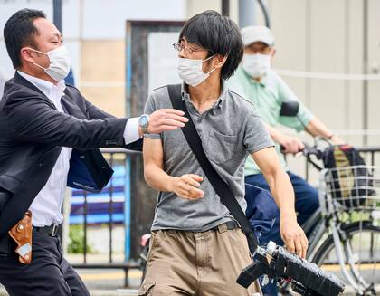 Tetsuya Yamagami, con un arma en la mano, es detenido cerca del lugar de los disparos en Nara, al oeste de Japón, el viernes 8 de julio de 2022.
