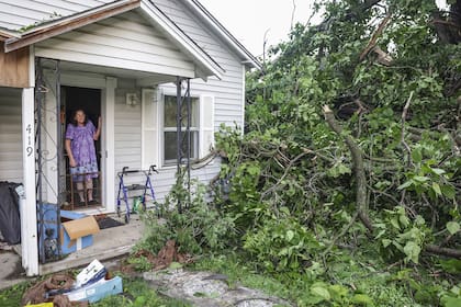 Connie Buckingham observa los daños causados por la tormenta desde la puerta principal de la casa de su hijo, donde ella también vive, el domingo 26 de mayo de 2024, en Claremore, Okla.