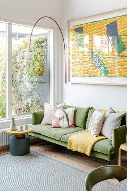 Textiles y mesa auxiliar en tonos verdes, amarillos y crudos dialogan con el cuadro de Richard Smith.