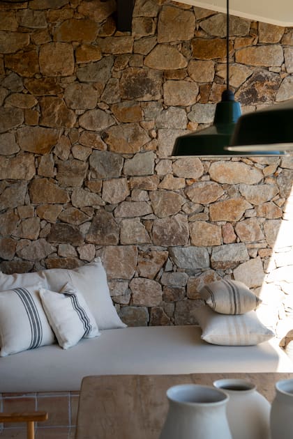 Texturas naturales y piedra a la vista refuerzan el espíritu mediterráneo en este rincón sereno de la casa.