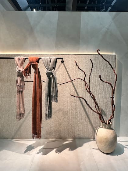 Texturas sutiles y una paleta cálida: Biancogres combinó relieves minerales con textiles suaves para destacar la profundidad y serenidad de sus superficies.