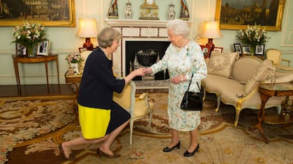 Theresa May se arrodilla frente a la reina Isabel II antes de asumir como Primera Ministra