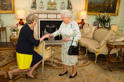 Theresa May se arrodilla frente a la reina Isabel II antes de asumir como Primera Ministra