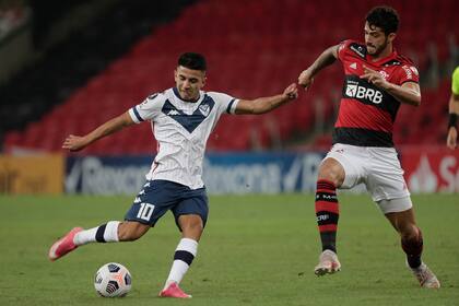 Thiago Almada, con la camiseta de Vélez, frente al defensor de Flamengo Gustavo Henrique