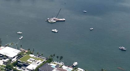 This image taken from video provided by WSVN-TV shows Miami-Dade Fire Rescue and others in boats around what appears to be a barge involved in an accident with a group of kids and an adult on a sailing boat during a sailing camp, Monday, July 28, 2025, in Miami. (WSVN-TV via AP)