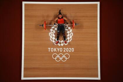 This picture taken with a robotic camera shows Nicaragua's Sema Nancy Ludrick Rivas competing in the women's 64kg weightlifting competition during the Tokyo 2020 Olympic Games at the Tokyo International Forum in Tokyo on July 27, 2021. (Photo by Chris GRAYTHEN / various sources / AFP)