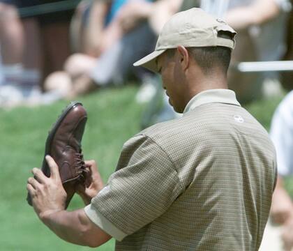 Tiger se quita la arena del búnker y vuelve a calzarse su zapato, durante la jornada de práctica en el Buenos Aires Golf Club