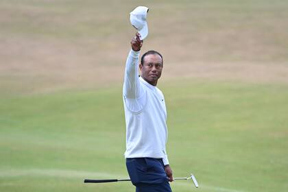 Tiger Woods, gorra en alto, saluda al público agolpado en el green del hoyo 18 de St. Andrews, donde se disputa el British Open 2022