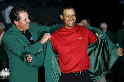 Phil Mickelson, el líder de "los rebeldes" del LIV Golf, le coloca la chaqueta verde a Tiger Woods en 2005