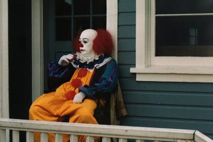 Tim Curry, caracterizado como IT, se está dando aire con un ventilador portátil durante el rodaje