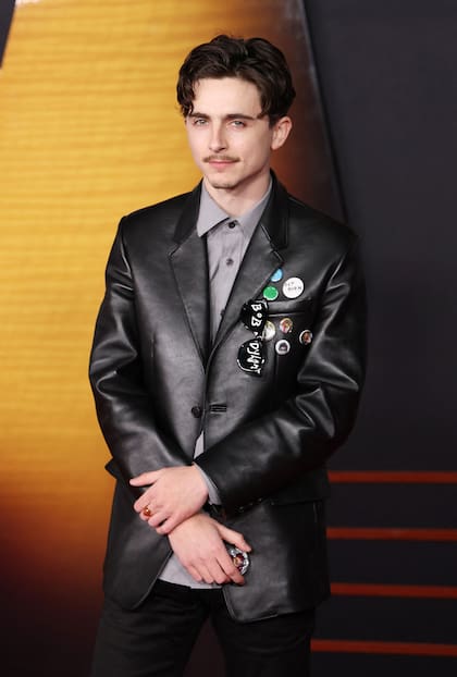 Timothee Chalamet, quien interpreta a Bob Dylan en esta biopic, arrasó con todos los flashes y felicitaciones durante su paso por la alfombra roja. El actor le hizo honor a su personaje con una chaqueta de cuero negra bien rockera. Los pins con frases y fotos de Dylan alrededor del bolsillo y las gafas negras con su nombre llamaron la atención de todos los presentes