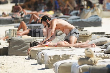 Atento a los requerimientos de su chica, Sebastián Yatra se ocupó tanto de aplicarle protector solar en la espalda como de buscarle bebidas en la barra del parador.