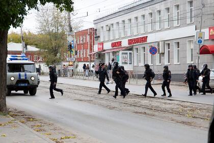 Agentes de policía corren a la Universidad Estatal de Perm en Perm, a unos 1100 kilómetros al este de Moscú