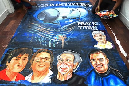 Los estudiantes de la escuela de arte dan los toques finales a una pintura que representa a cinco personas a bordo de un sumergible llamado Titán, que desapareció cerca de los restos del Titanic, en Mumbai el 22 de junio de 2023