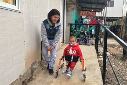 Tiziano, el niño de 2 años que recibió una de las sillas de ruedas de Uno X Uno, junto a su mamá, Florencia.
