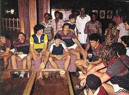 Tocando la guitarra en la gira con Boca de 1982, ante la mirada de Maradona, entre otros.