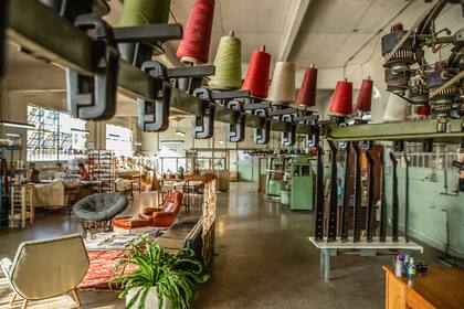 Todavía se conservan los carretes de hilos que se usaban cuando la fábrica estaba en funcionamiento. Son protagonistas de la decoración que le da identidad al espacio.