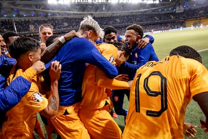 Todos abrazan al defensor que anotó un gol que puede ser clave para las aspiraciones de Países Bajos