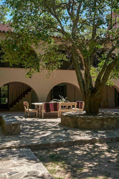 Todos estos espacios comunican con puertas ventanas a la galería frente a la parrilla. Un piso de piedras antiguas y un árbol resguardan la mesa y bancos en madera drift que resiste la intemperie.