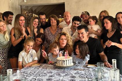 Todos juntos a la hora de soplar las velitas. En el centro de la foto y con camisa animal print, Lizie, la mamá de la cumpleañera.