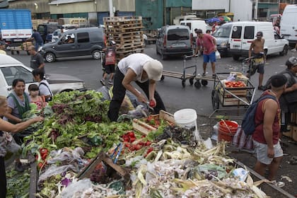 Todos los días, cientos de personas recorren los volquetes de desechos del Mercado Central buscando llevarse las frutas y verduras que desechan los puesteros