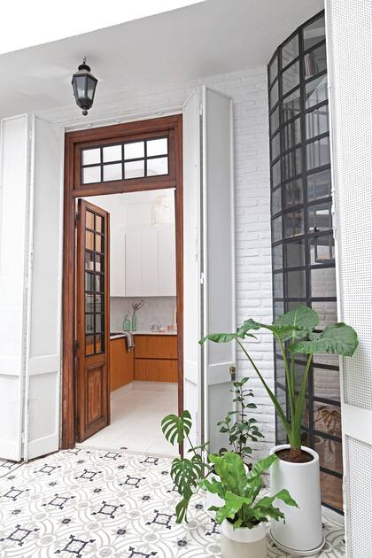 Todos los ojos al piso: granítico en la cocina y calcáreo de base blanca en el patio, para una transición suave.