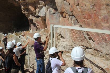 Todos los visitantes tienen que usar cascos por seguridad para poder transitar los pasillos estrechos de la Cueva de las Manos