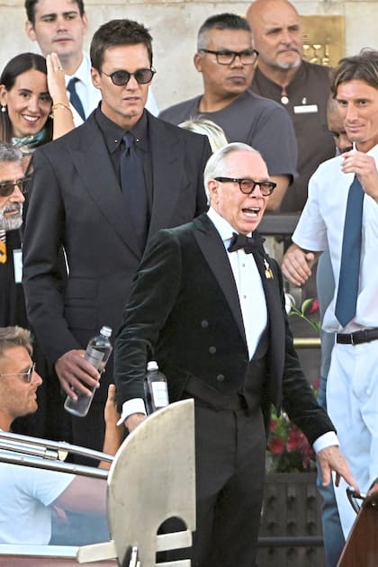 Tom Brady lució un traje negro con camisa a tono y corbata azul oscura y Tommy Hilfiger un frac con moño y camisa blanca