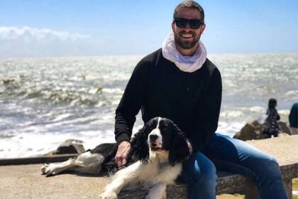 Tomás Caldiroli Stankievich junto a su perra Cleo, con el océano atlántico de fondo, en Mar del Plata