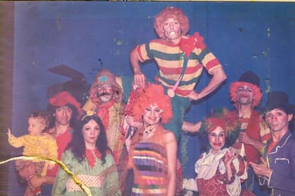 Tomás en brazos de su padre Pipistrilo junto al elenco de Piripincho en el teatro Caras y Caretas, de Rosario. Su mamá, la payasa Pipiola, está vestida de rojo, con peluca multicolor.