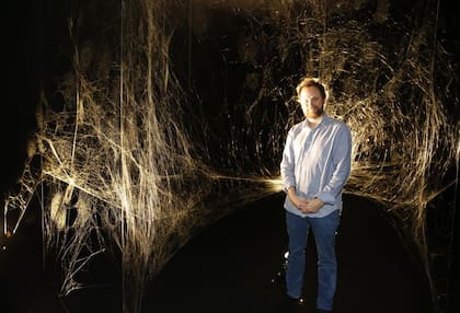 Tomás Saraceno junto a la tela construida por miles de arañas en el museo Moderno, en 2017