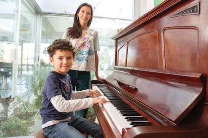  Tomás toca el piano ante la mirada atenta de su mamá. 

