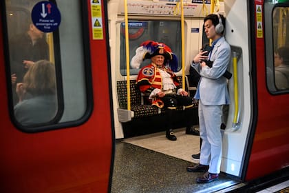 Tony Appleton, vestido con su disfraz de pregonero, toma el subte hacia el centro de Londres, el 5 de mayo de 2023, para entretener de forma no oficial a las personas que esperan ver la coronación.