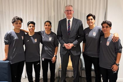 Tony Burke con las cinco futbolistas iraníes que inicialmente accedieron a recibir el asilo de Australia (Australia Ministry of Home Affairs via AP)